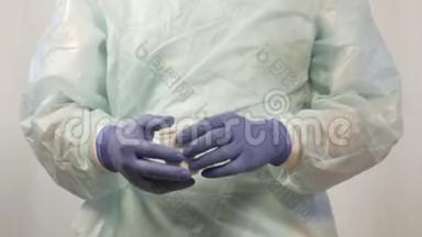 <strong>戴</strong>着<strong>医用手套</strong>的男医生的手从罐子里取出药丸，这是病人必须服用的。